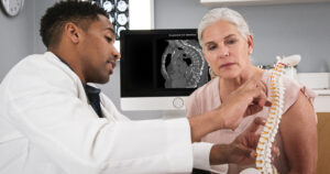 radiologist explains to a patient about the diagnosis of vertebral compression fracture